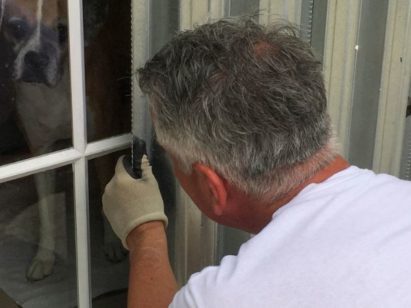 Man inspecting hurricane shutters