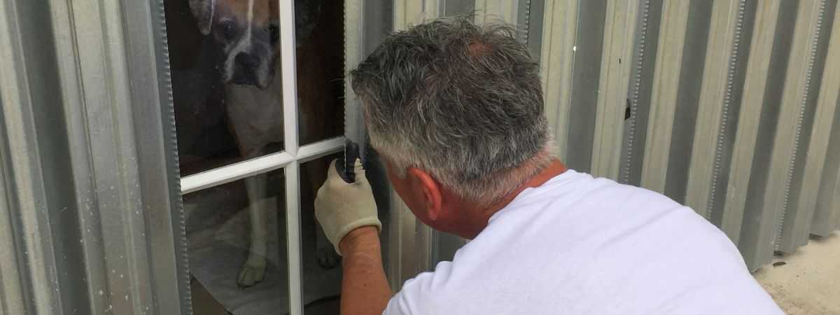 Man inspecting hurricane shutters