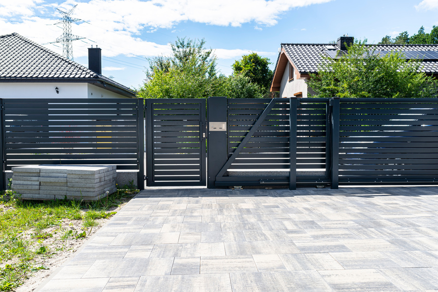 A modern panel fence in anthracite color, a visible gate