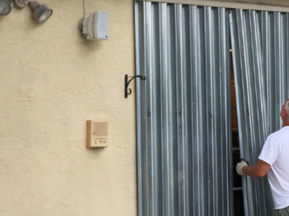 Man hanging sheet metal shutters
