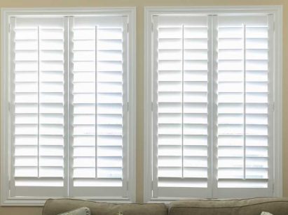 A set of open white impact shutters in a room