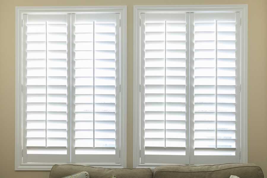 A set of open white impact shutters in a room