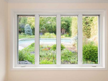window looking on summer backyard with pool and garden
