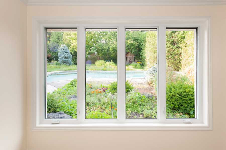 window looking on summer backyard with pool and garden